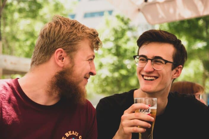 Dos buenos amigos están tomando unas cervezas bajo el sol