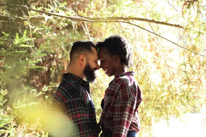 A couple is smiling at each other face to face 