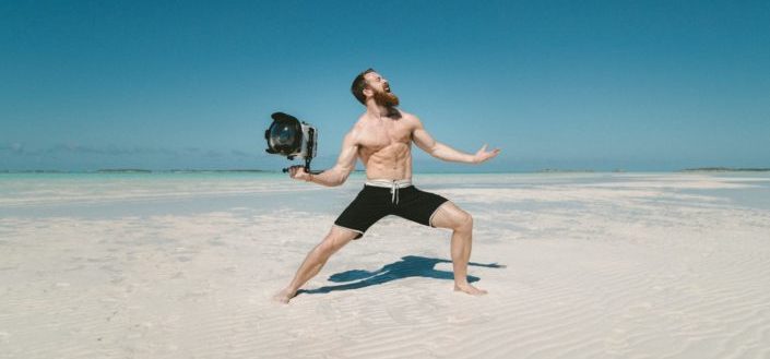 Man holding huge lens striking a pose