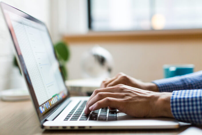 man typing on his laptop