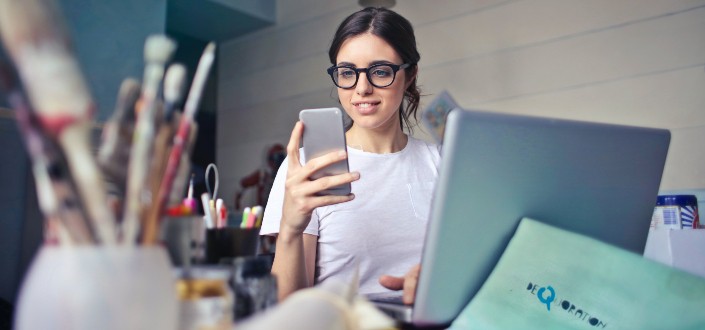 woman smiling while looking at her phone 