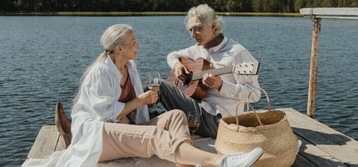 Man and woman sitting on wooden dock