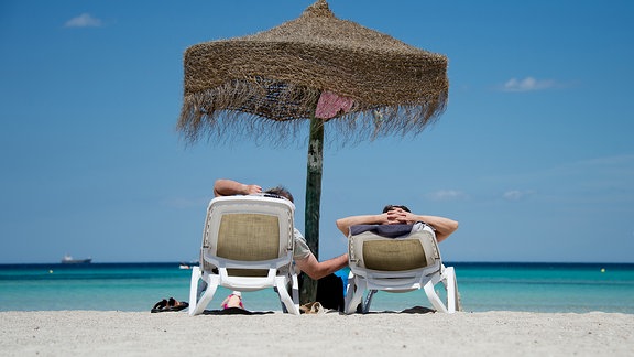 Urlauber entspannen sich am Plaja-de-Muro-Strand auf Mallorca