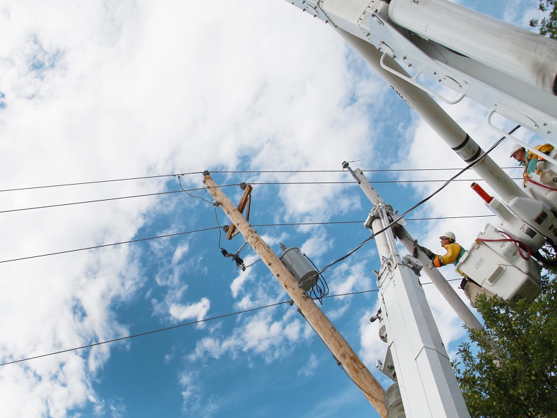 Worker in bucket truck, working on overhead power lines