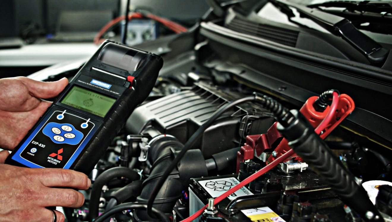 technicien qui s'occupe d'un véhicule Mitsubishi