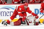 Detroit Red Wings center Robby Fabbri (14) checks Carolina Hurricanes right wing Jesper Fast (71) during the third period of an NHL hockey game, Thursday, Dec. 14, 2023, in Detroit. (AP Photo/Carlos Osorio)