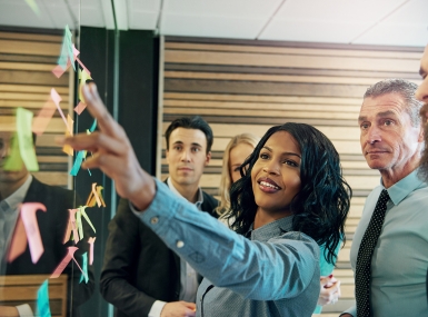 A group of people looking at sticky notes