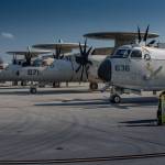 Multiple E-2 planes lined up on a runway.