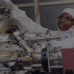 Two people in protective suits in a lab