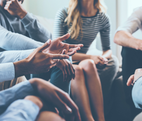 Closeup of people's hands while they're sitting in a circle talking