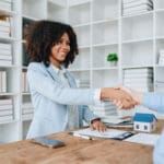 The bank's Female African american Mortgage Officers shake hands with customers to congratulate them after signing a housing investment loan agreement.