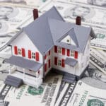 Two-story house with five dollar bills background