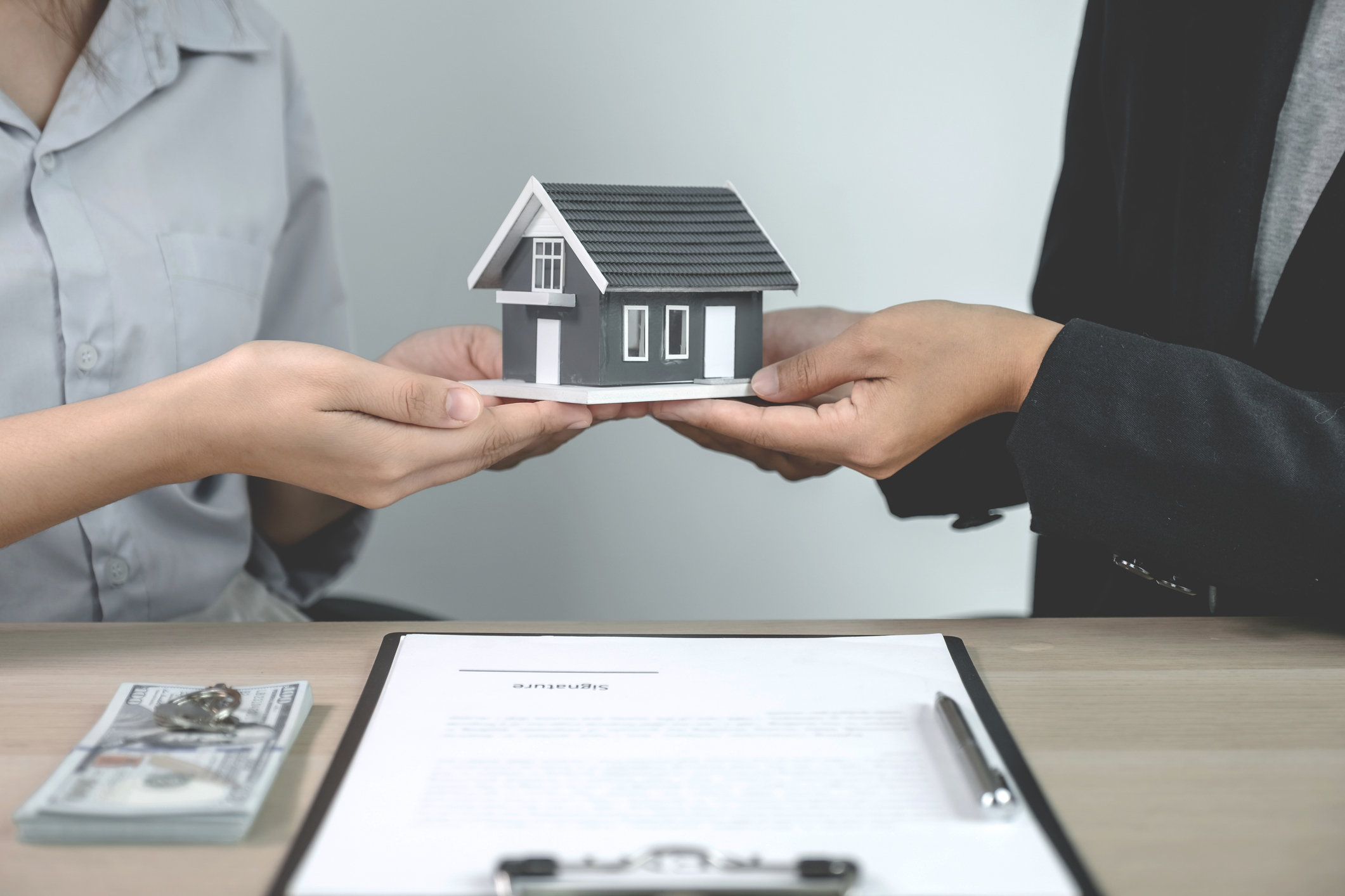 Hand a real estate agent, hold the home model, and explain the business contract, rent, buy, mortgage, loan, or home insurance to the buyer woman.