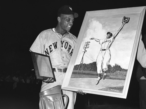 Willie Mays of the Giants shows some gifts he received before the game from fans in Trenton, N.J., , where he used to play before they lost their franchise, Aug. 11, 1957. (AP Photo)