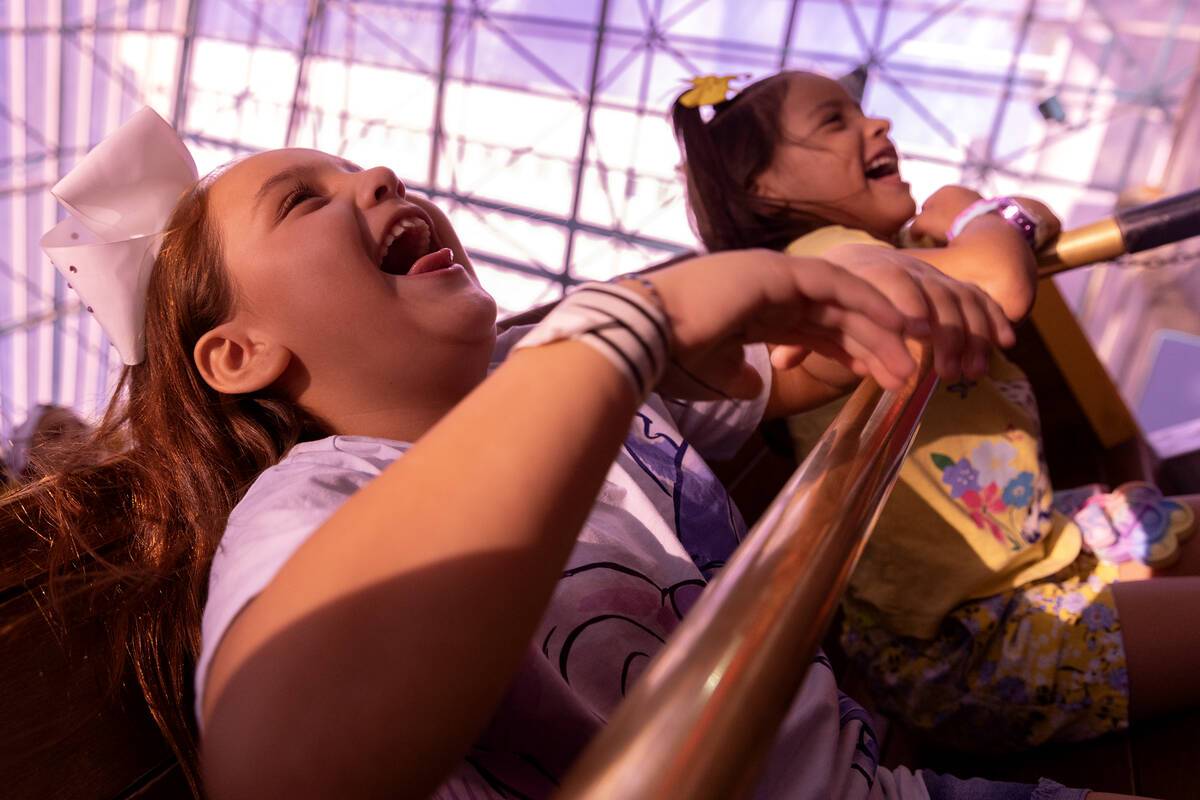 Children ride a rollercoaster.