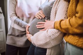 pregnant person with hands on their stomach