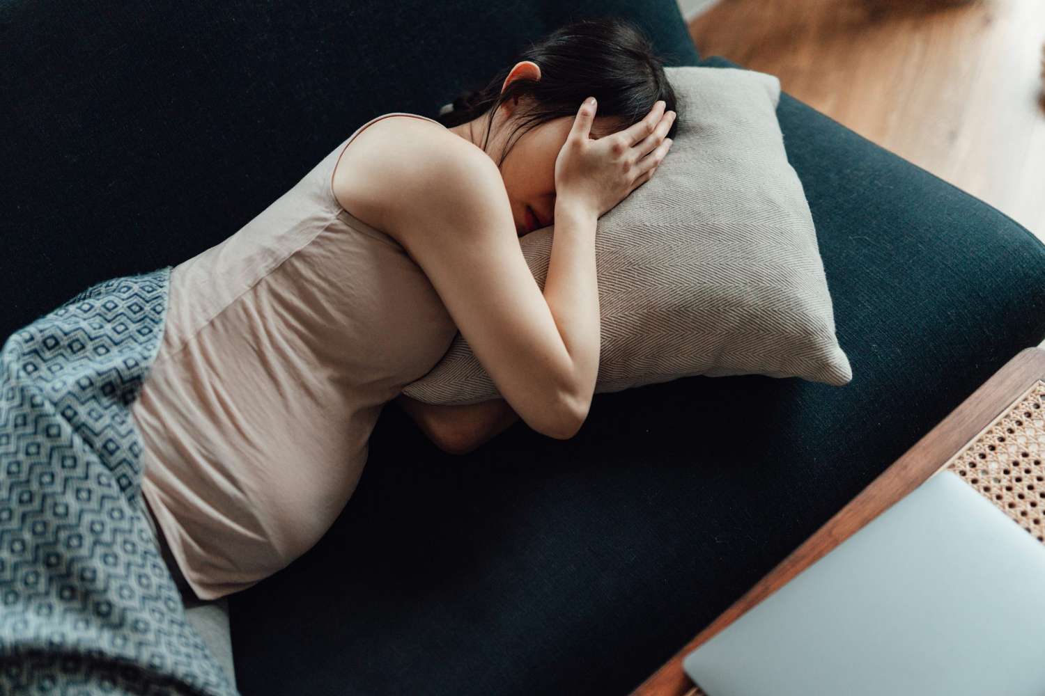 pregnant person laying down covering their eyes