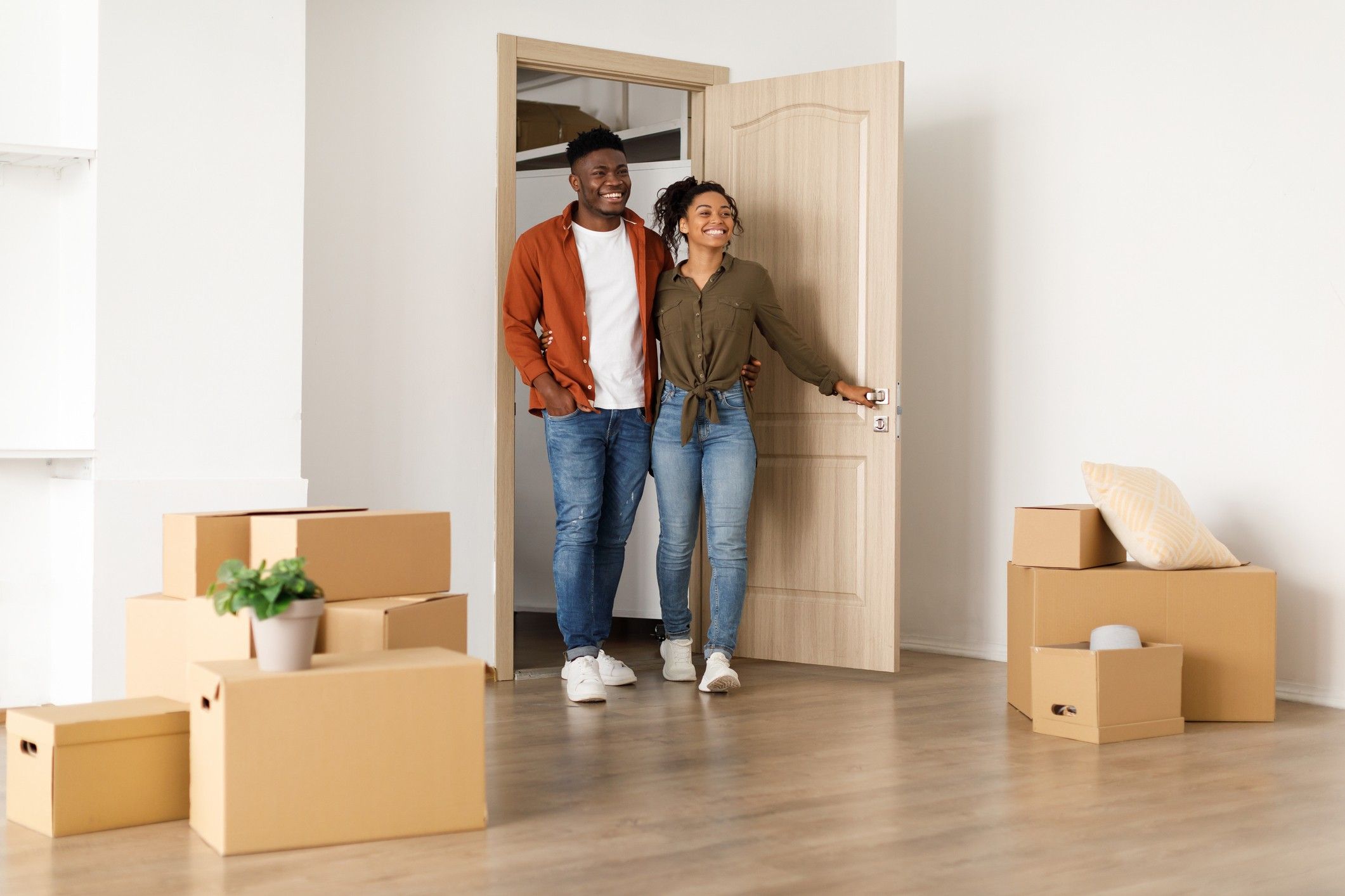 A man and woman stand in the doorway of a new apartment. 