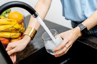 photo - Woman Filling Glass with Tap Water