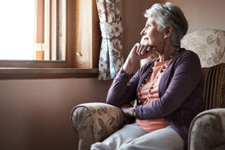 photo - Senior Woman Sitting Alone in Livingroom