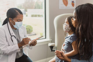 photo - Mother and daughter with doctor at appointment in office