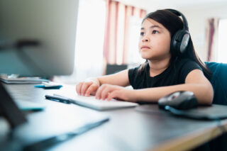 photo - Young Girl at Home on Computer Doing Homework