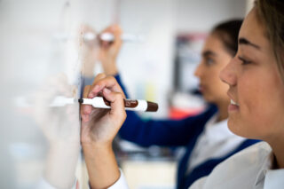 photo - Teenage girls writing on a whiteboard