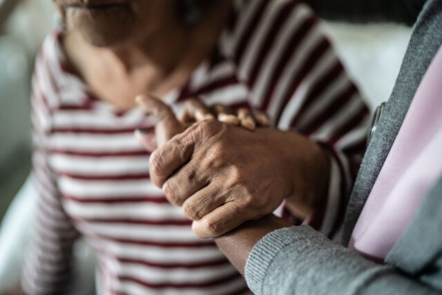 photo - Caregiver and Senior Woman Holding Hands