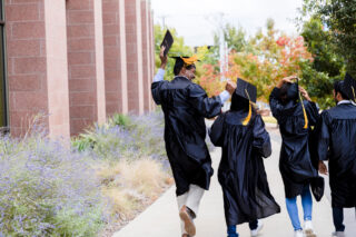 photo - Diverse Graduates Walk Out to Family after Ceremony