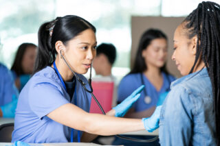 photo - Nurse in Training Checks Patient's Pulse