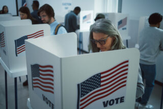 photo - Mature Woman Votes in Booth at Polling Station