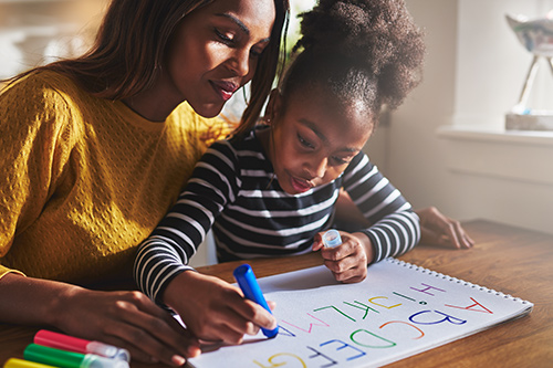 Mother and daughter writing the alphabet together