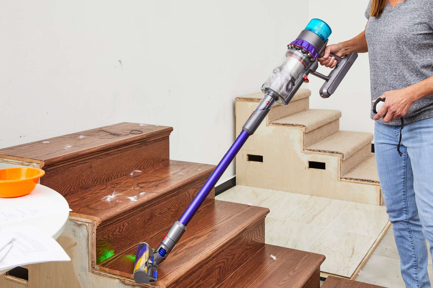 A person using the Dyson Gen5detect to vacuum a wooden staircase