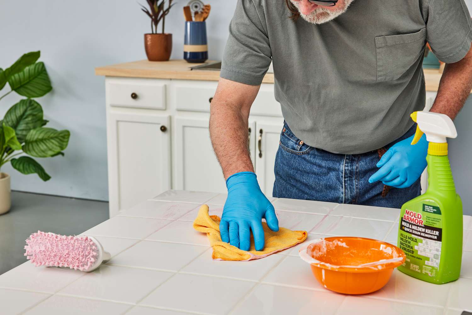 A person uses a microfiber cloth and Home Armor Instant Mold and Mildew Stain Remover to clean a countertop