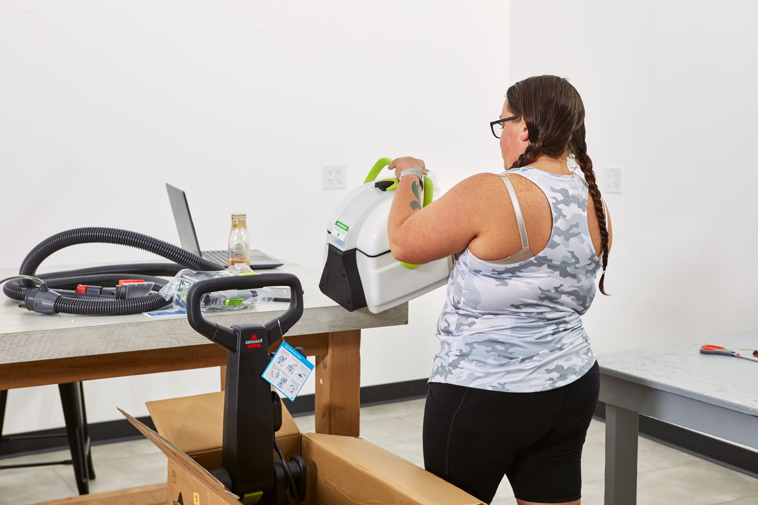 Person setting the main body of the Bissell Big Green Pet Pro Carpet Cleaner on a table