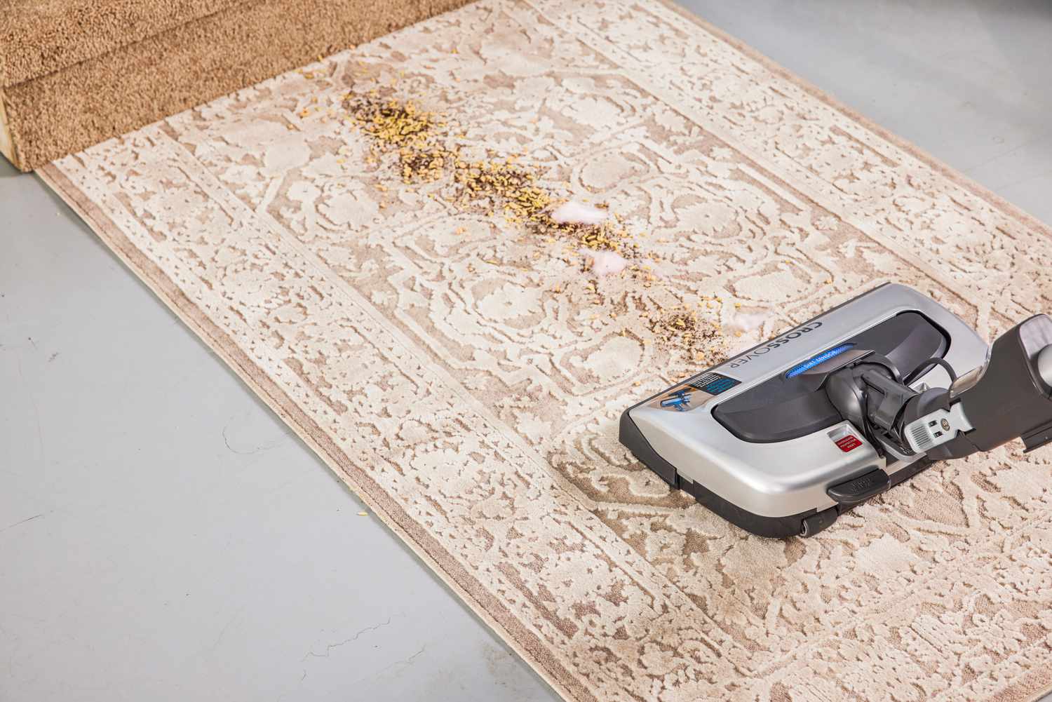 A person uses the Kenmore Elite CrossOver Bagged Canister Vacuum 21814 to vacuum a rug