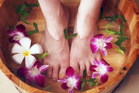 Why Your Feet Hurt: Common Causes of Foot Pain. closeup shot of woman soaking her feet in water