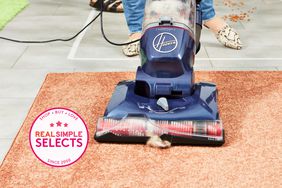The Hoover Max Complete vacuum being used to clean a rug with a Real Simple selects badge. 