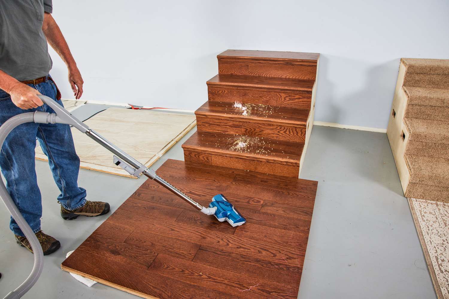 A person cleans a wood floor using the Kenmore Compact Bagless Canister Vacuum.