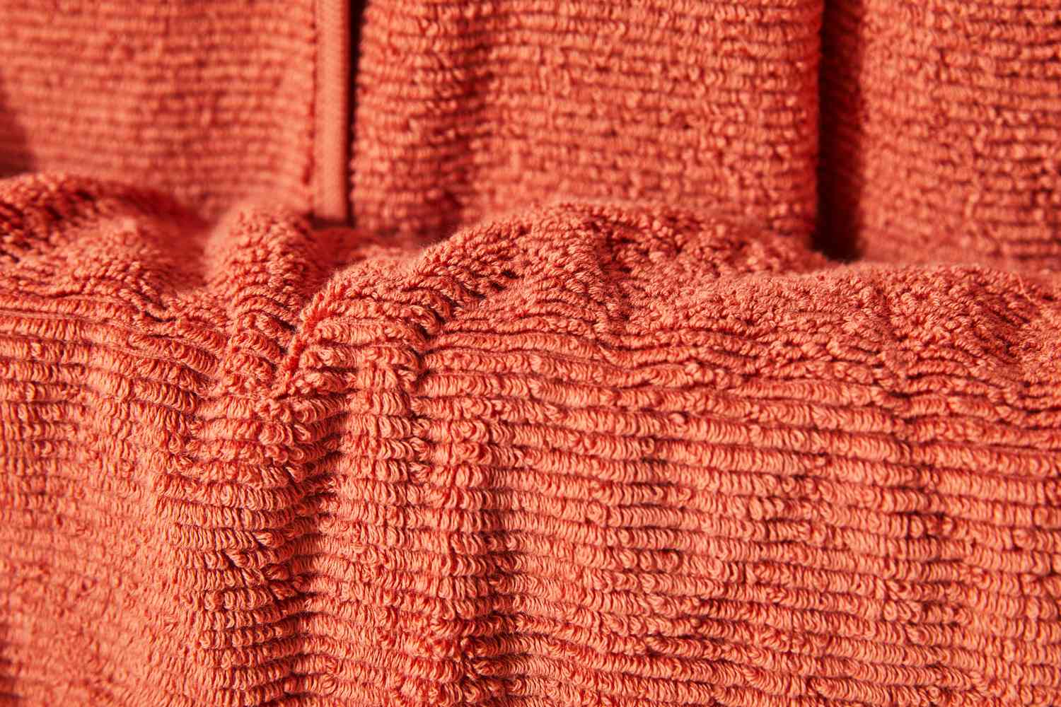 Closeup of a Brooklinen Organic Ribbed Bath Towel in rust color