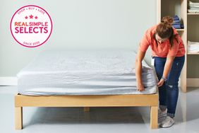A person fixing a bed with the Sheets & Giggles Eucalyptus Sheet Set