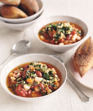 Two bowls of three-bean chili with spring pesto are served along side crusty bread.