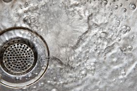 Top view of water flowing down a stainless sink and drain