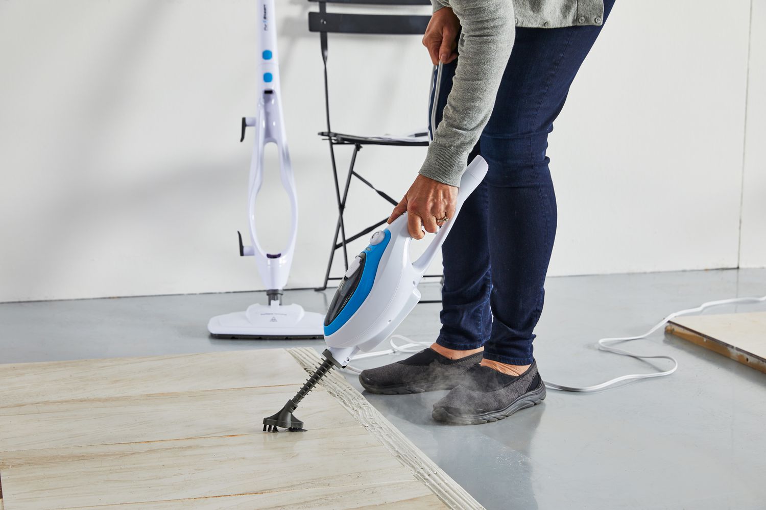 Person using PurSteam 10-in-1 Steam Mop handheld attachment to clean a tile floor