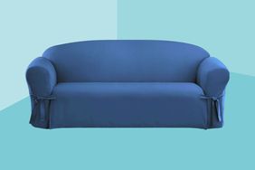 The SureFit Cotton Duck One Piece Sofa Slipcover atop a decorative blue background