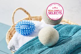 A variety of dryer balls on top of towels in a woven basket