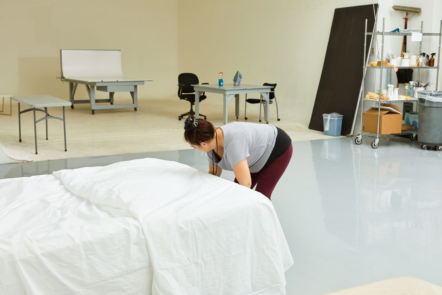 Woman making a bed with a white Boll & Branch Signature Hemmed Set