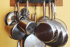 Close-Up Of Kitchen Utensils Hanging From Rack On Wall