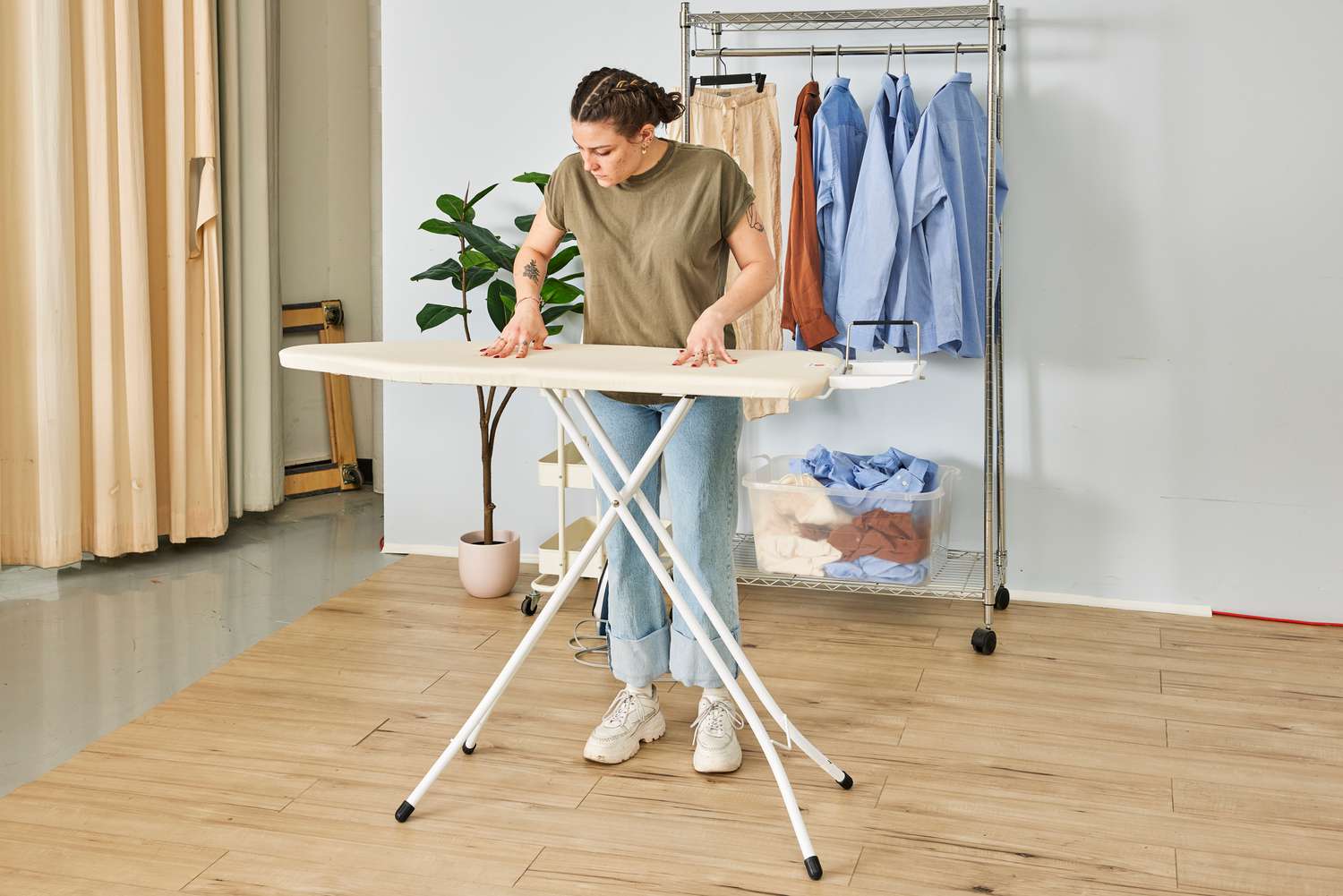 A person pressing the top of the Brabantia Size B Ironing Board