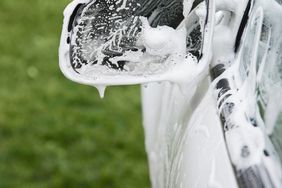 Soapy car side mirror and door showing how to wash a car at home